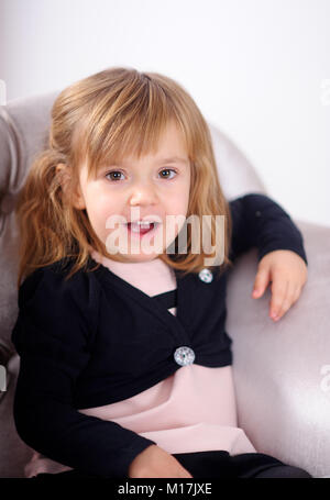 portrait of the girl of 2 3 years sitting in a chair cute fair haired