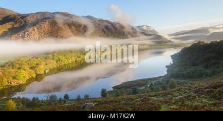 Early morning mist hangs on the mountainside above Lyn Dinas and shrouds the valleys of the Snowdon horseshoe beyond Stock Photo