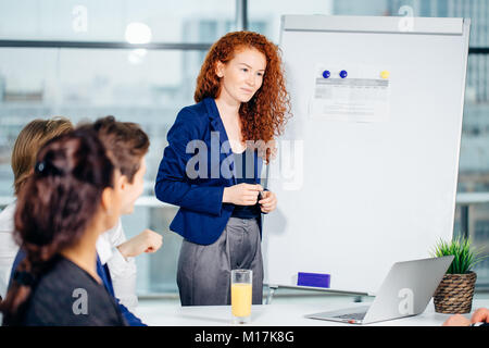 Business woman giving presentation to colleagues in office Stock Photo