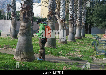Boy using tablet in Naples, Italy - public garden Stock Photo