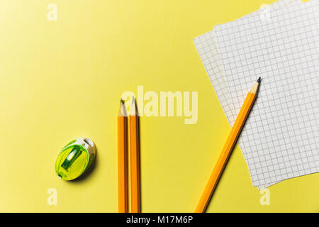 Sharpener, list for recording, pencils on a yellow background Office theme. Stock Photo