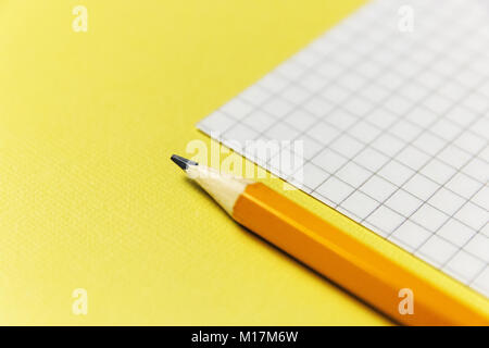 notebook and a green pencil on blue background. Office theme Stock Photo