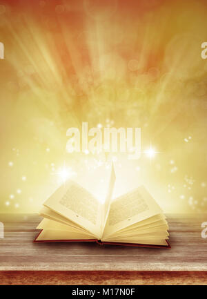 Open book on table in front of magical background Stock Photo
