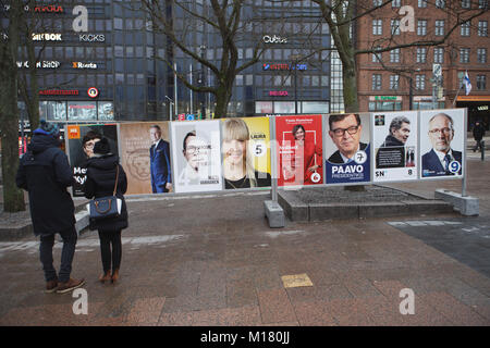 Helsinki, Finland, 28th January, 2018. People on the street at the posters of Presidential candidates in the day of first round of Presidential elections. Second round will be held on 11 February if necessary Credit: StockphotoVideo/Alamy Live News Stock Photo