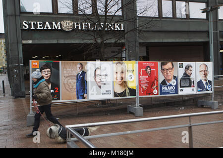 Helsinki, Finland, 28th January, 2018. People on the street at the posters of Presidential candidates in the day of first round of Presidential elections. Second round will be held on 11 February if necessary Credit: StockphotoVideo/Alamy Live News Stock Photo