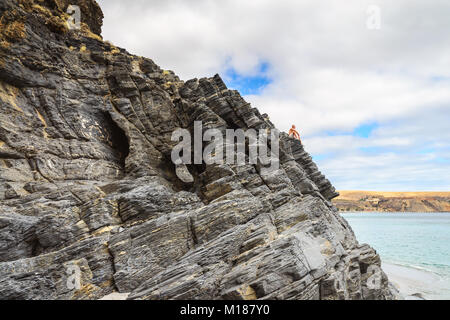 Man sitting on the edge of the cliff at Rapid Bay, South Australia Stock Photo