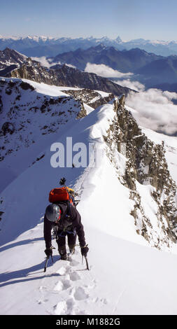 mountain climber exiting the steep north face of Gran Paradiso in the Italian Alps and heading to the summit Stock Photo