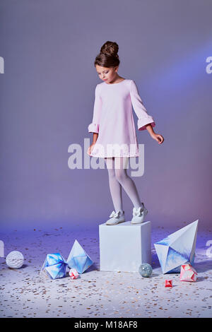 Romantic little girl in beautiful pink dress.Designer collection. Origami and minimalism. Fashion children. Romantic little girl in beautiful pink dress. Stock Photo