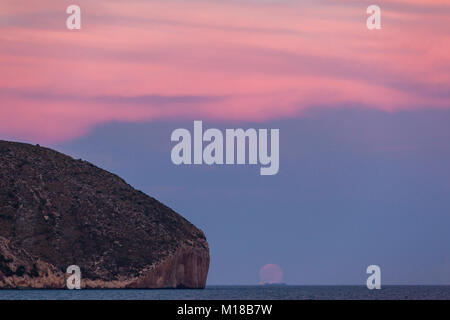 Sunset with moonrise at Cap d'Or in Teulada-Moraira, Alicante, Spain Stock Photo