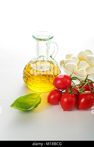 Fresh mozzarella cheese with tomato, basil and olive oil on white background Stock Photo