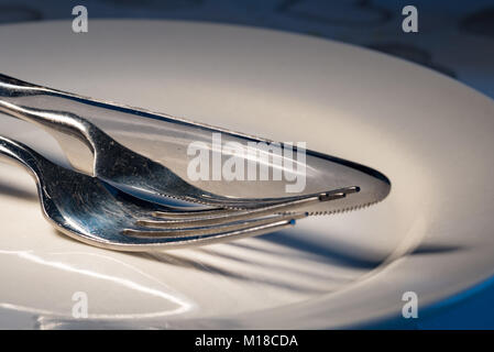 Stainless steel cutlery on white plate Stock Photo