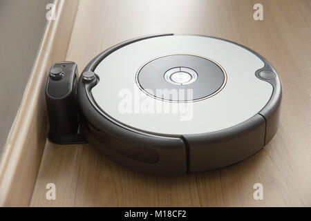 robot vacuum cleaner return to charging at dock in clean room floor Stock Photo