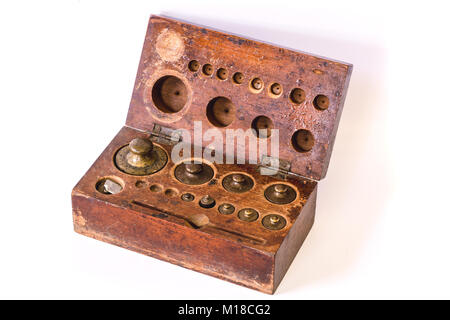 antique brass weight scale set on old wood box isolated on white Stock Photo