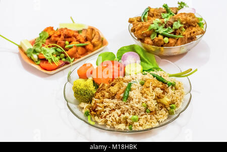 Spicy Bengali Indian dish of vegetable fried rice with chicken kosha as side dish and crispy chicken prawn as starter Stock Photo