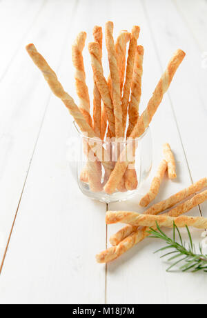 Homemade cheese bread sticks in glass on white wooden background, bakery concept Stock Photo