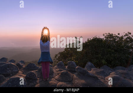 kid traveler stretching arms on sunset view point background at Phu Hin Rong Kla National Park Phitsanulok Province, Thailand Stock Photo