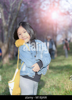 Happy traveler girl smile on cherry blossom background, Unseen Thailand at phu lom lo Loei Thailand. travel concept Stock Photo
