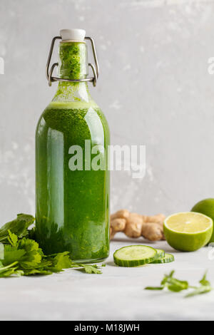 Healthy green vegetable detox juice in a glass bottle. Vegan cucumber, parsley green juice. Stock Photo
