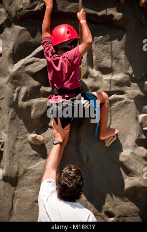 A father pushes his on up on rock climbing Stock Photo