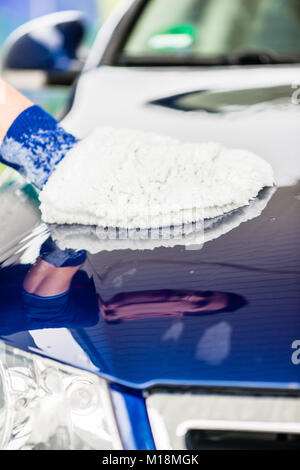 Man polishing the bonnet of his luxury car Stock Photo