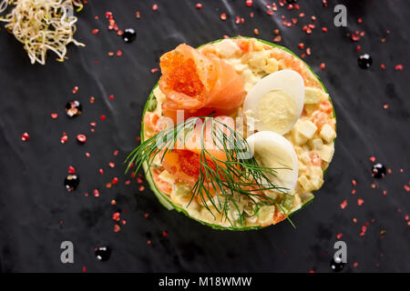 Top view olivier salad with eggs, salmon and caviar. Stock Photo