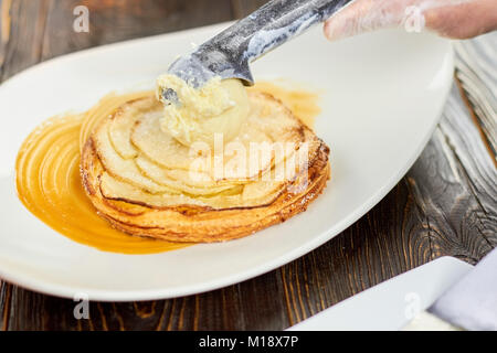 Adding ice cream ball to an apple tart. Stock Photo