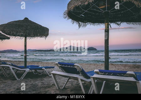 Beach beds and straw umbrellas at Playa de Muro Beach, Alcudia, Mallorca, Spain, beautiful six kilometres long Blue Flag, white sandy beach. Stock Photo