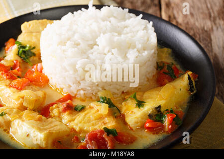 Fish stew in coconut milk with vegetables and rice close-up on a plate. horizontal Stock Photo