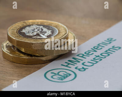 HM Revenue and Customs tax return and self assessment form with some loose change - people having to 'sharpen the pencil' to pay taxes Stock Photo