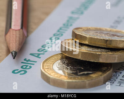 HM Revenue and Customs tax return and self assessment form with some loose change - people having to 'sharpen the pencil' to pay taxes Stock Photo