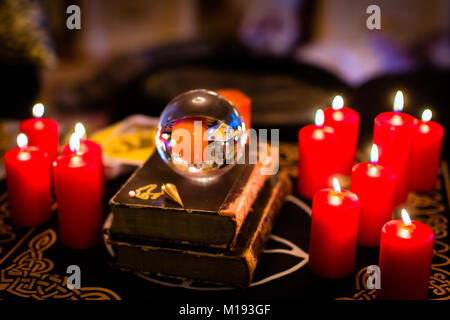 Crystal ball in the candle light to prophesy Stock Photo