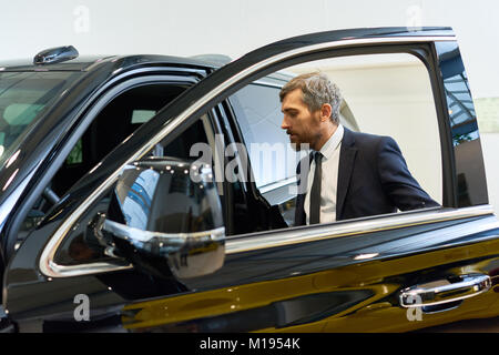 Successful Businessman Getting into Car Stock Photo