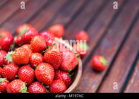 Strawberries in bowl on wooden background. Copy space Stock Photo