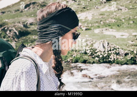 Portrait of a girl with a backpack in the mountains. Travel Lifestyle concept landscape on background vacations adventure journey. Active leisure outd Stock Photo