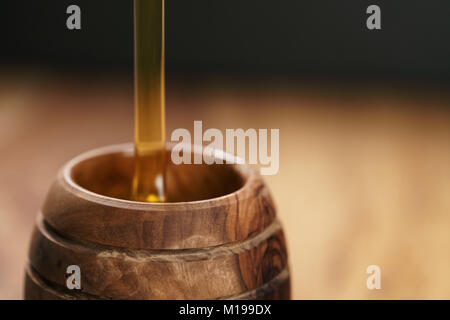 organic honey pour into wooden pot Stock Photo