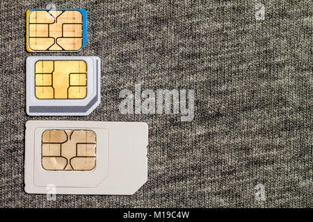 Set of mini, micro and nano simcard. Isolated on grey cloth texture background Stock Photo