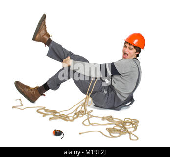 A young worker in grey uniform tied up with rope on white isolated background. Stock Photo
