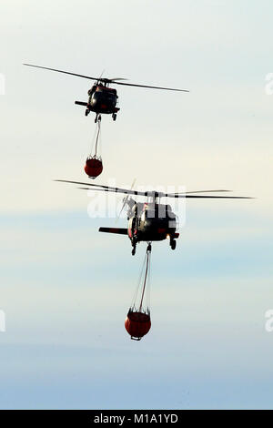 A pair of California National Guard UH-60 Black Hawk helicopters from B Company, 1st Battalion, 140th Aviation Regiment, return to Camarillo Airport in Camarillo, California, Sun., Dec. 10, 2017, after making water drops on the Thomas Fire burning in Ventura County. (U.S. Air National Guard photo by Senior Airman Crystal Housman) Stock Photo