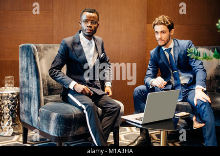 businessman using laptop to discuss information with colleague in modern office Stock Photo