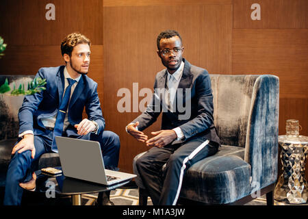 businessman using laptop to discuss information with colleague in modern office Stock Photo
