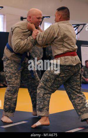 Staff Sgt. Eugene Patton (top), Colorado Army National Guard, grapples with Sgt. 1st Class Maurice Gomez, New Mexico Army National Guard, during their combatives bout in the 2012 Region VII Best Warrior Competition at Camp San Luis Obispo, Calif., April 25. The combatives event challenged competitors to submit their opponent within six minutes using an authorized hold, or win by majority of points gained throughout the match using various moves. (Army National Guard photo/Spc. Grant Larson) Stock Photo