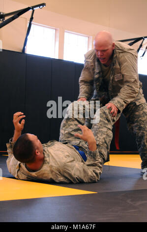 Staff Sgt. Eugene Patton (top), Colorado Army National Guard, grapples with Staff Sgt. Brian Bower, Arizona Army National Guard, during their combatives bout in the 2012 Region VII Best Warrior Competition at Camp San Luis Obispo, Calif., April 25. The combatives event challenged competitors to submit their opponent within six minutes using an authorized hold, or win by majority of points gained throughout the match using various moves. (Army National Guard photo/Spc. Grant Larson) Stock Photo