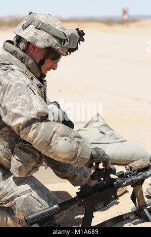 120509-Z-PP889-007 Spc. Matthew Schoch with the California Army National Guard’s Bravo Company, 1st Battalion, 184th Infantry (Light), makes adjustments to his weapon's scope to get a tighter shot group. The troops zeroed their rifles during range iterations May 9 during a National Training Center rotation at Fort Irwin, Calif. (Army National Guard photo/Spc. Grant Larson) Stock Photo