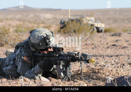 120512-Z-PP889-006 Sgt. Josh Hopark with the California Army National Guard’s Bravo Company, 1st Battalion, 184th Infantry (Light), scans his sector of fire during a field training exercise May 12 at the National Training Center in Fort Irwin, Calif. At this point the troops have be issued laser tag equipment that they wear on their uniform and attach to their weapon. The muzzle of the rifle is covered and blanks are loaded. The light shock of the kickback when fired emits a beam that if it strikes an opponents laser sensor they are considered &quot;hit&quot;. (Army National Guard photo/Spc. G Stock Photo