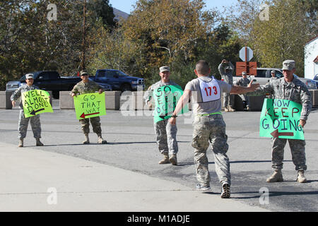 Cadre at Camp San Luis Obispo hold signs and show support for Sgt. Miguel Ramirez II, Headquarters Detachment, Joint Forces Headquarters, as he runs the Unknown Distance Run Nov. 18 in the California Army National Guard’s 2015 Best Warrior Competition at San Luis Obispo, California. Holding signs: Sgt. Colby Ballesteros, Sgt. 1st Class Hobert Gabuat, Sgt. 1st Class Jack McPhetridge and Staff Sgt. Garth Pedrotti. (U.S. Army National Guard photo/Staff Sgt. Eddie Siguenza) Stock Photo