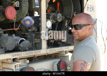 Spc. Ernan Ramirez from Echo Company, 1st Battalion, 140th Aviation Regiment, California Army National Guard, operates pumps that fuel a UH-60 Black Hawk July 13 at Coalinga Municipal Airport, Fresno County, California, as CalGuard air assets were called to battle the Garza Fire in mid-July 2017. (Army National Guard photo/Staff Sgt. Eddie Siguenza) Stock Photo