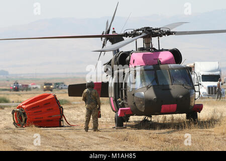 Sgt. Bob Batham of the California Army National Guard’s 1st Battalion, 140th Aviation Regiment, eyes the rotor blades as his UH-60 Black Hawk starts up prior to a July 13 Garza Fire mission at the Coalinga Municipal Airport, Fresno County, California. (Army National Guard photo/Staff Sgt. Eddie Siguenza) Stock Photo