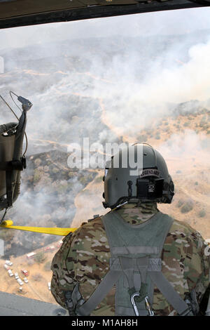 Sgt. Bob Batham of the California Army National Guard’s 1st Battalion, 140th Aviation Regiment, watches smoke billowing from the Garza Fire at Tar Canyon Road, Kings County, California. Five CalGuard UH-60 Black Hawks responded to the wildfire that consumed more than 40,000 acres and still actively progressing as of July 14. (Army National Guard photo/Staff Sgt. Eddie Siguenza) Stock Photo