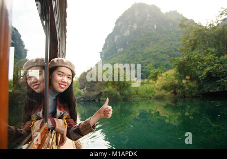Girl enjoying the scenery from a wooden tourist boat Stock Photo