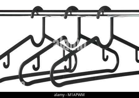 Three empty black coat / clothes hangers on a clothes rail with a white background. Stock Photo